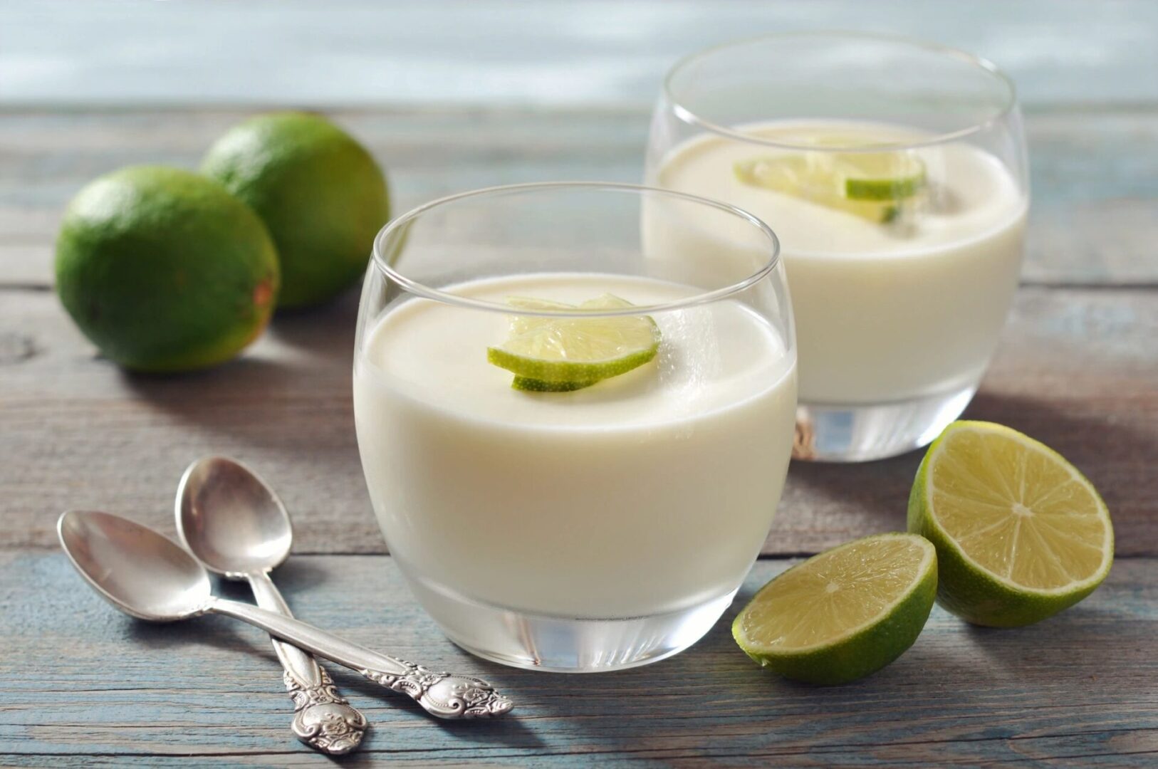 Two glasses of milk with lime slices on top.