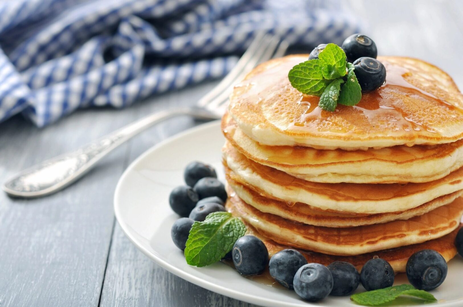 A plate of pancakes with blueberries on top.