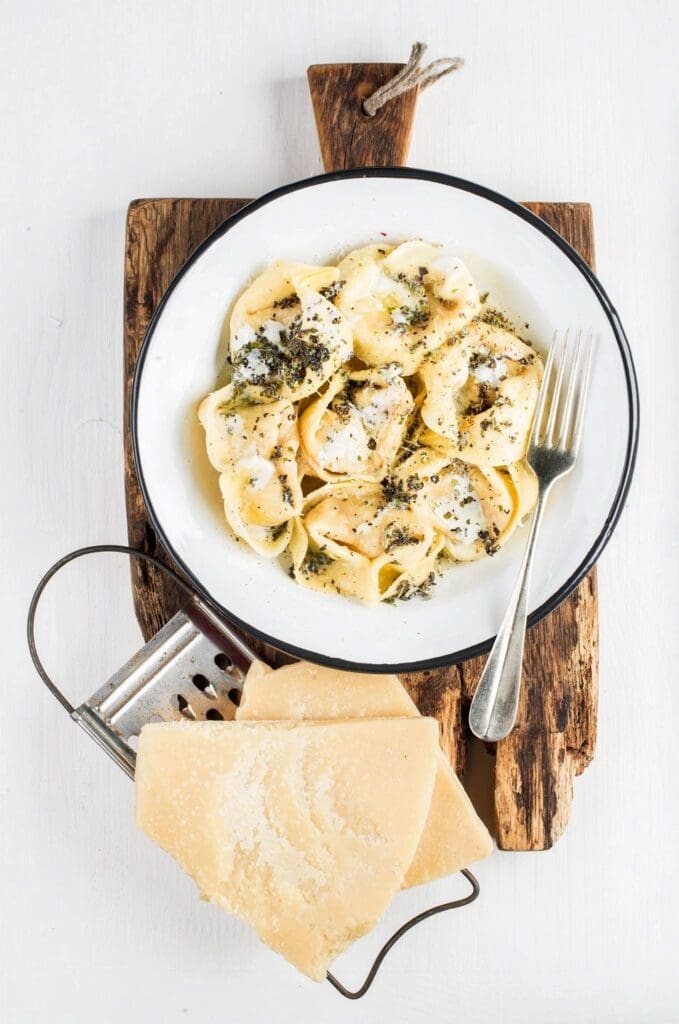 A bowl of pasta with cheese on top.