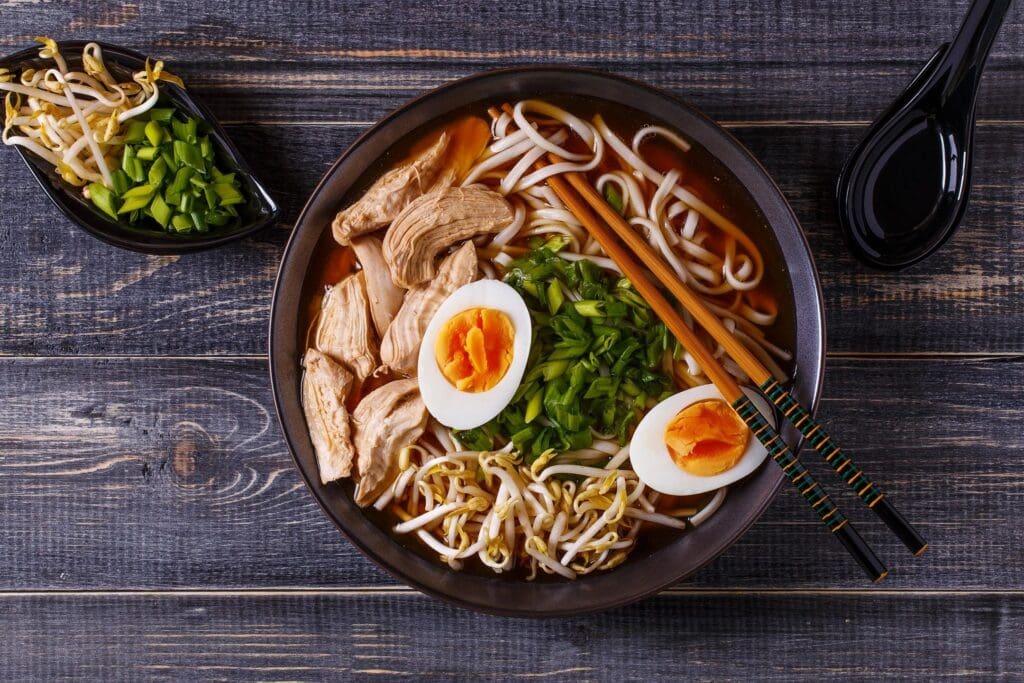 A bowl of ramen with chicken and eggs.