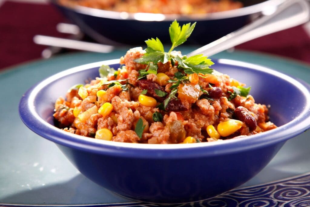 A bowl of rice and beans with cilantro.