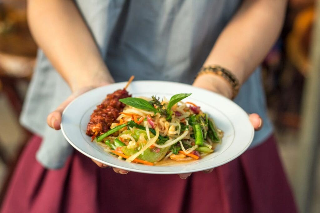 A person holding a plate of food on top of their lap.