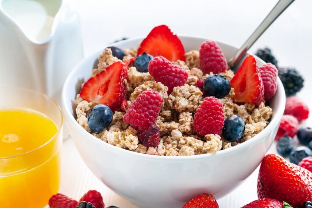 A bowl of cereal with berries and bananas