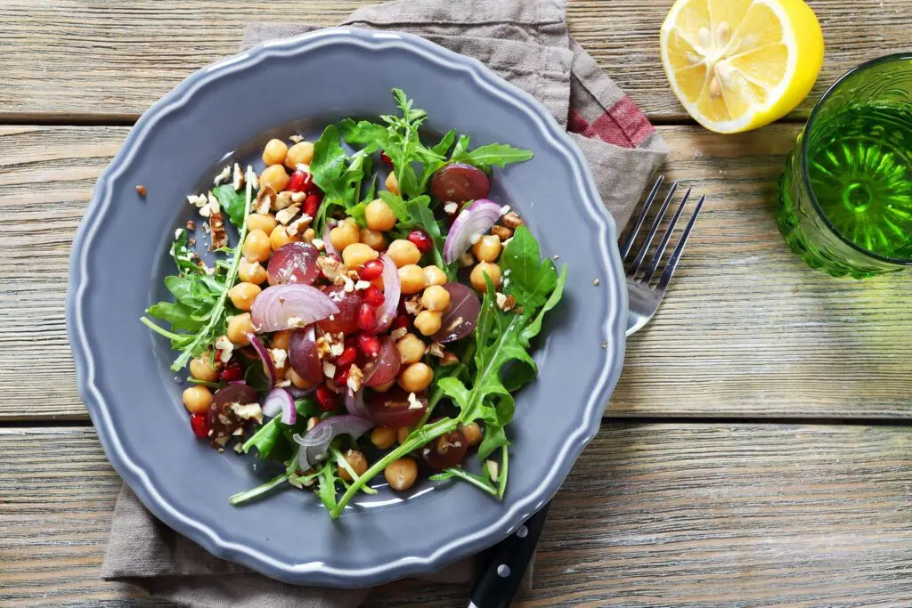 A bowl of salad with chickpeas and greens.
