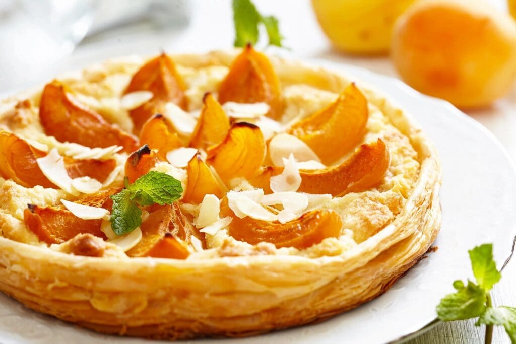 A close up of an orange and almond pastry