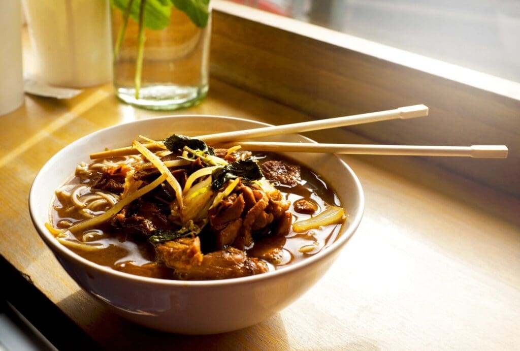 A bowl of soup with meat and noodles.