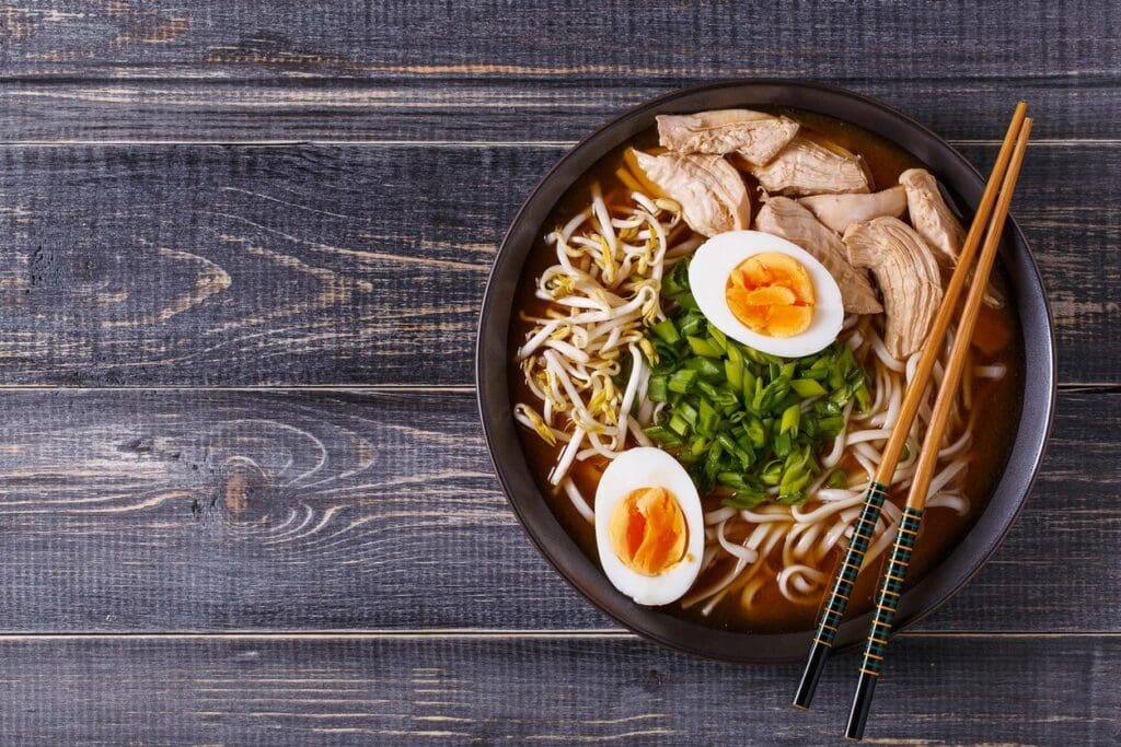 A bowl of ramen with chicken and eggs.