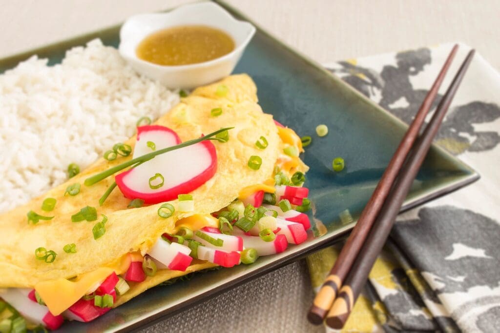 A plate of food with rice and sauce on the side.