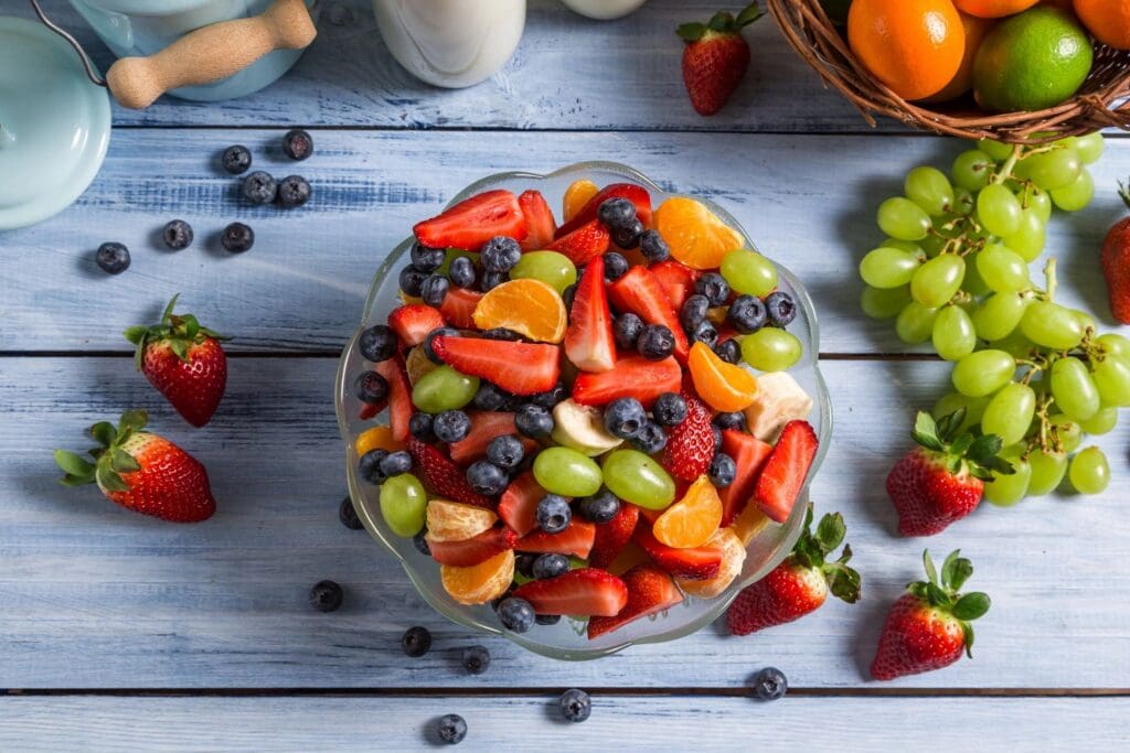 A bowl of fruit is sitting on the table.