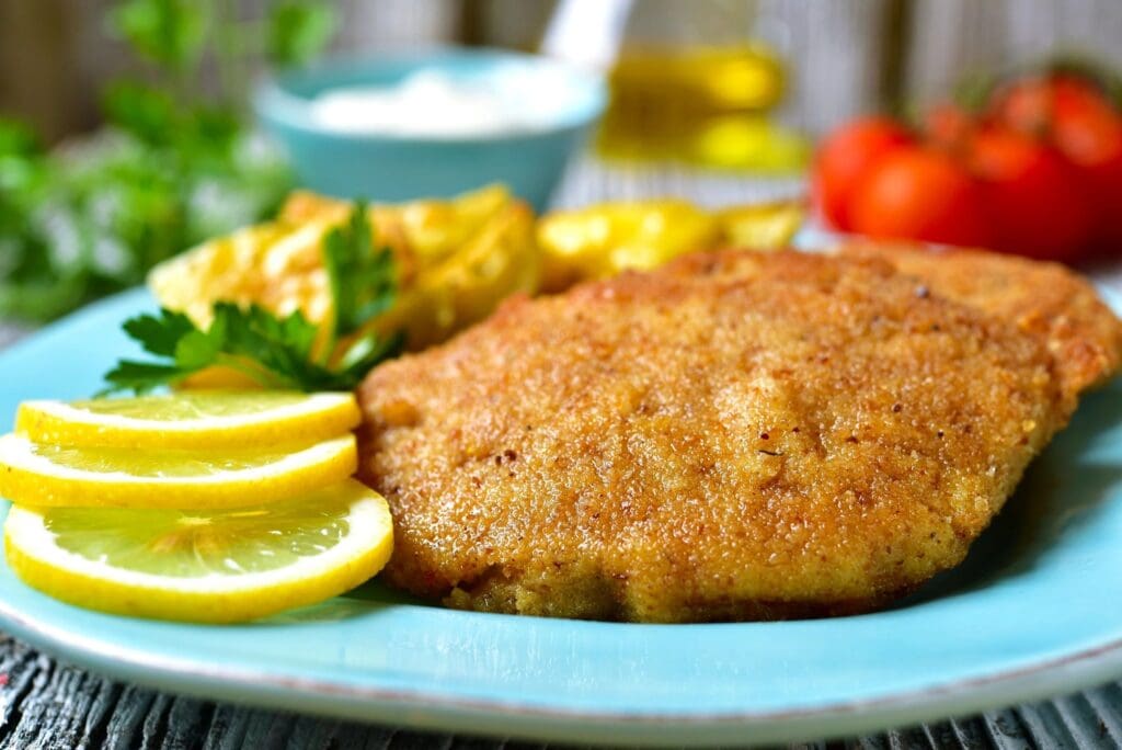 A plate of food with lemon and meat on it.