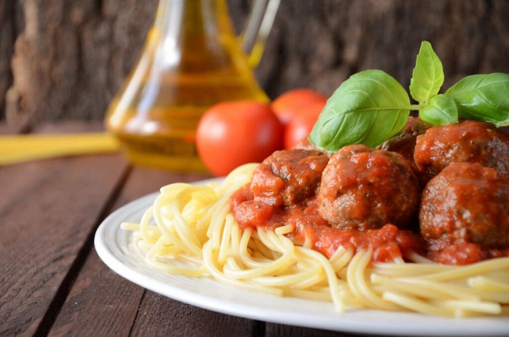 A plate of spaghetti and meatballs on top of a table.