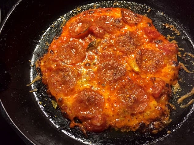 A pizza sitting on top of a pan covered in sauce.