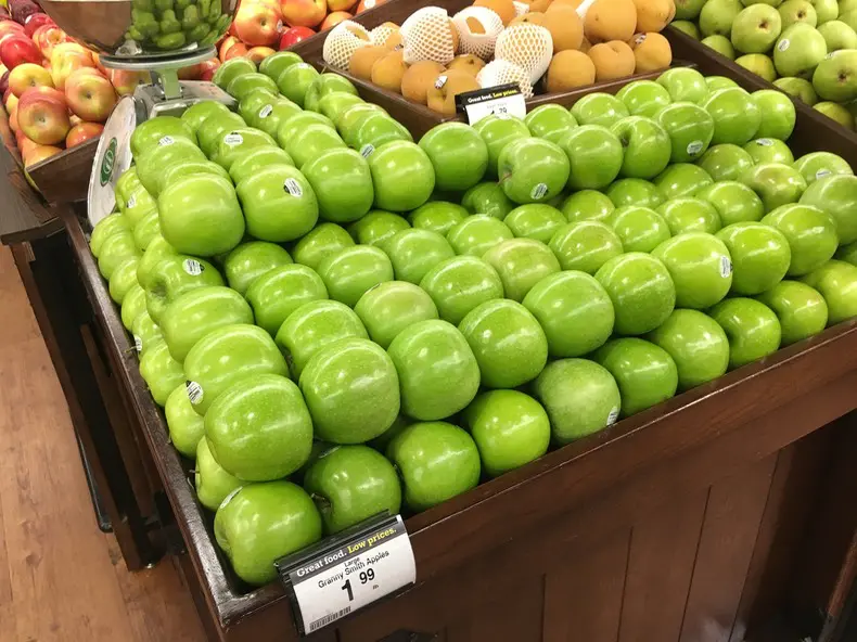 A display of green apples in a store.