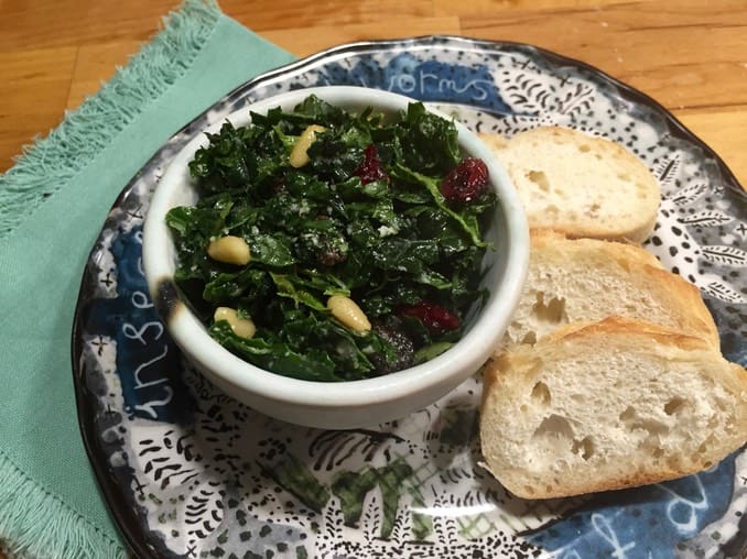 A bowl of greens and bread on a plate.