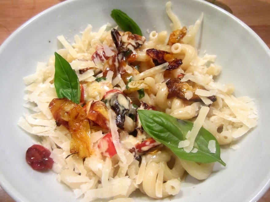 A bowl of pasta with some vegetables and cheese