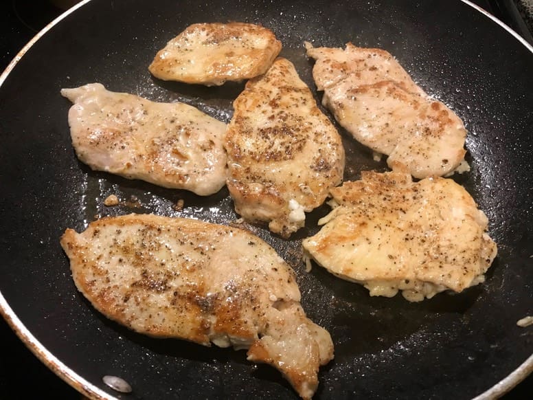 A pan with some meat cooking in it