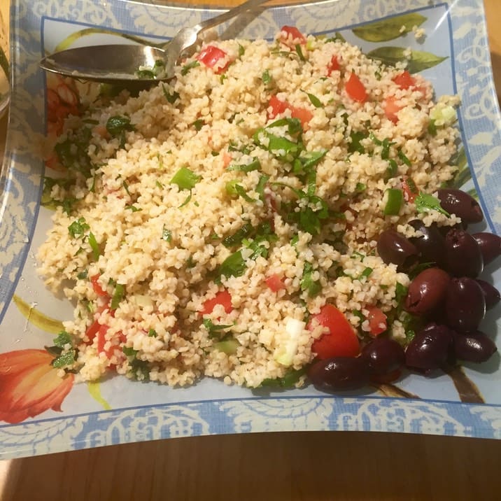 A plate of rice and grapes on the table.