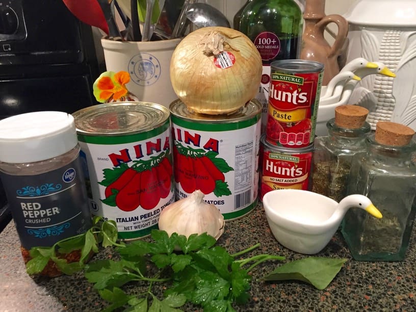 A table with many cans of tomatoes and garlic.