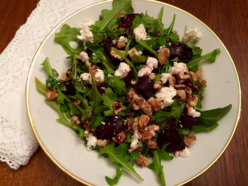 A salad with feta cheese and beets on top of it.