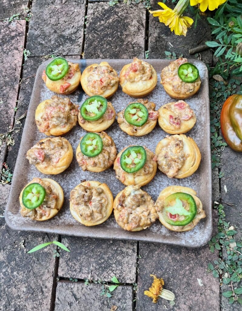 A tray of jalapenos and meat on top of some bread.