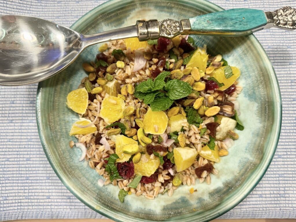 A bowl of food with rice and fruit on it.