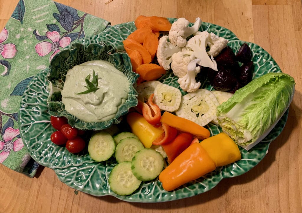 Veggies and dip on a green plate.