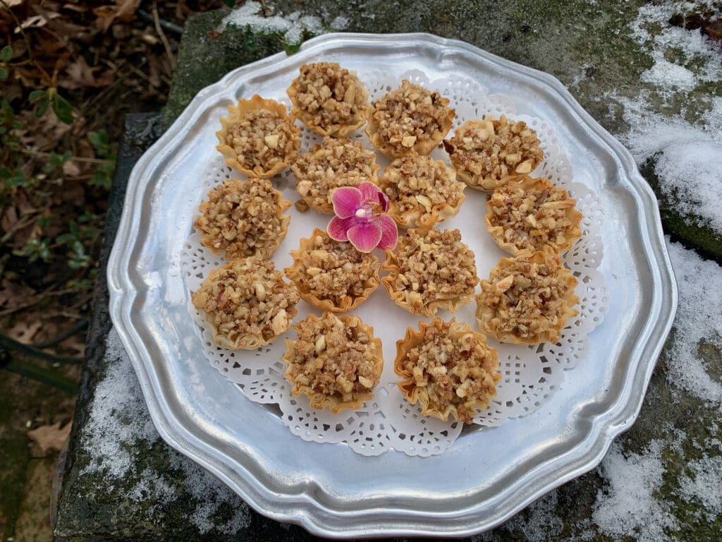 Nutty pastry tarts on a silver tray.