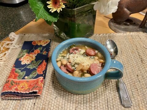 A bowl of white bean soup with sausage.