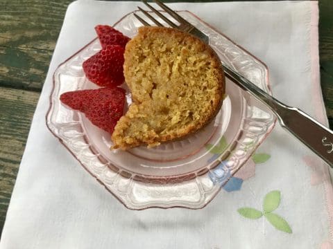 Slice of cake on a pink plate with strawberries.