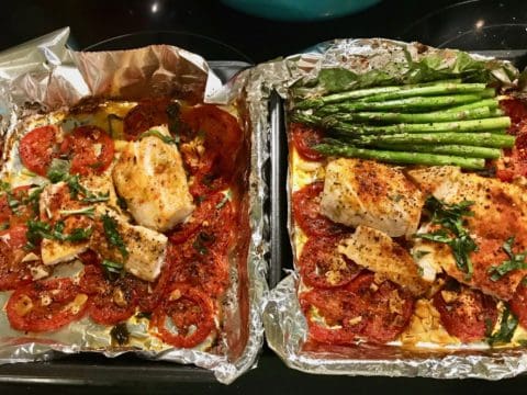 Baked fish with tomatoes and asparagus.