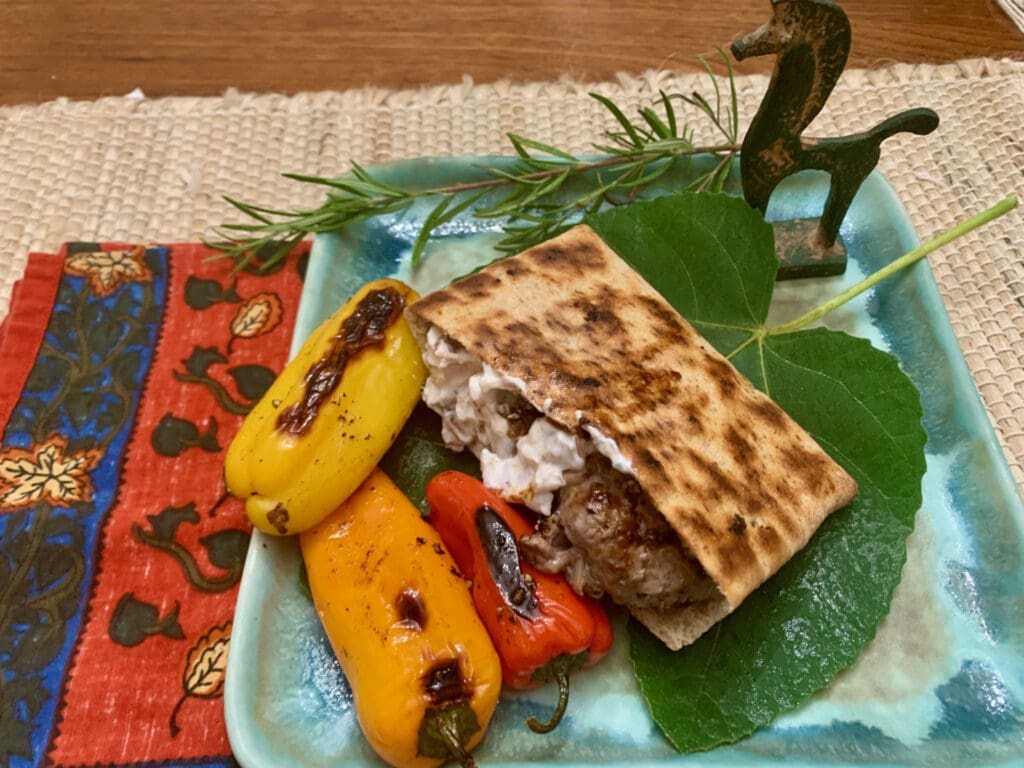 Grilled pita, peppers, and meat on plate.