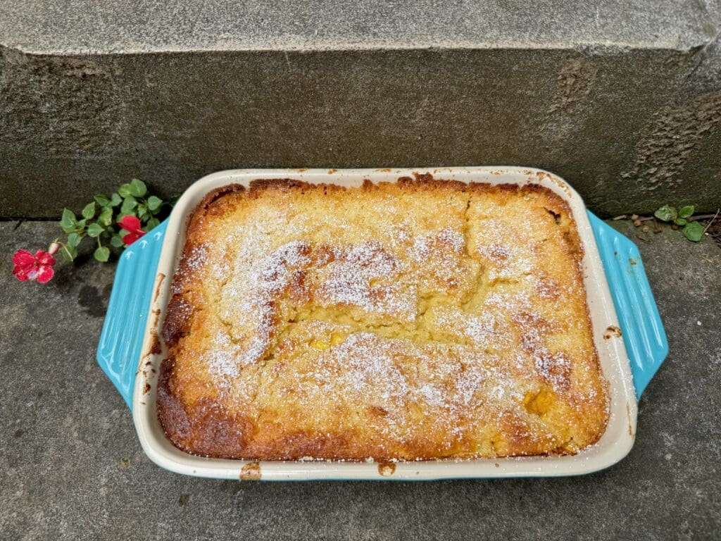 Baked peach cobbler with powdered sugar.