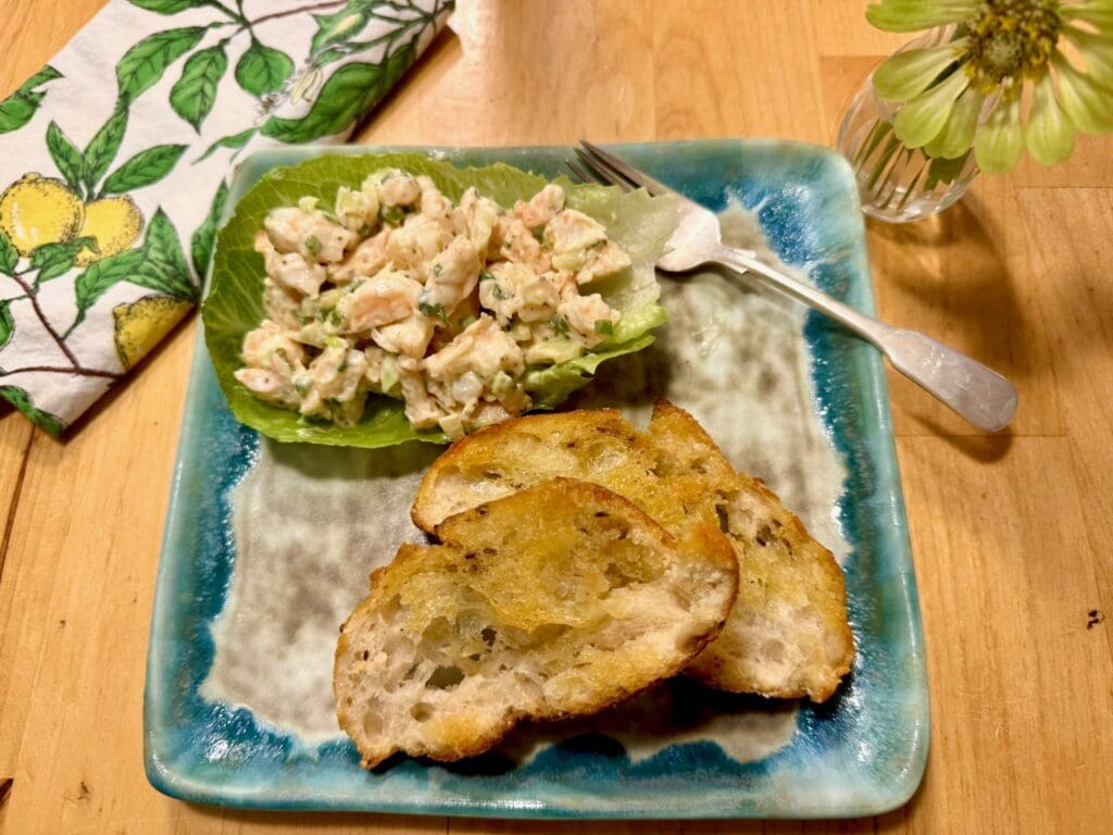 Shrimp salad with toasted bread on plate.