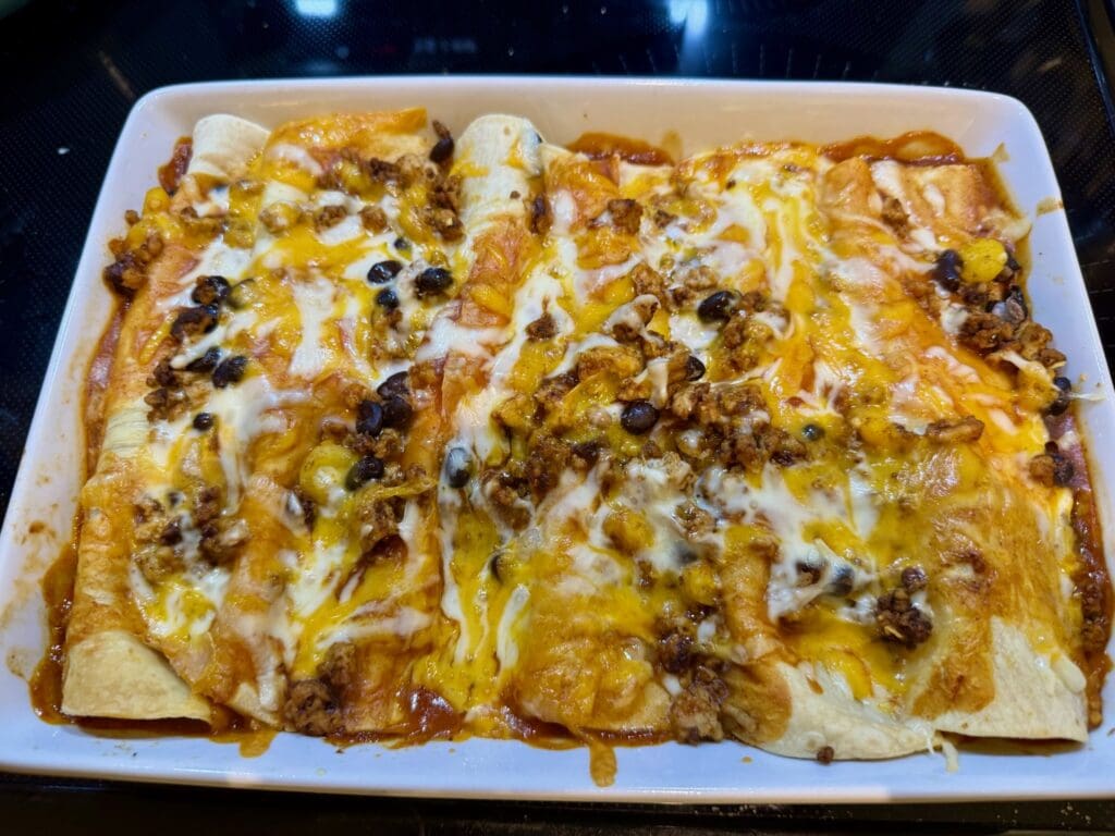 Cheesy enchiladas with beans and meat.