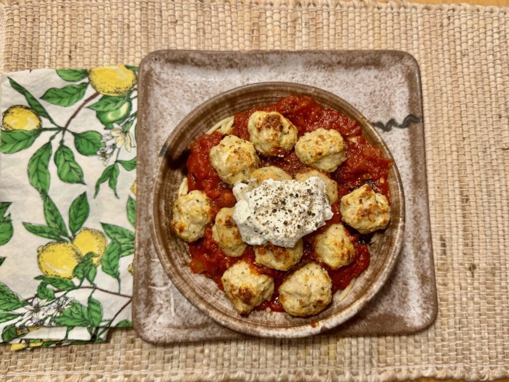 Meatballs with sauce and cream on plate.