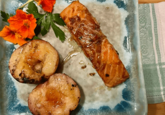 A plate of food with salmon and potatoes.