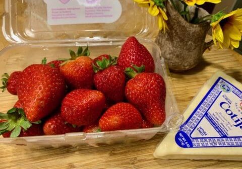 Fresh strawberries in a container with cheese.