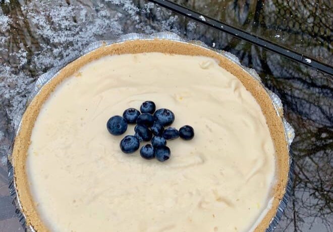 A pie with blueberries on top of it.