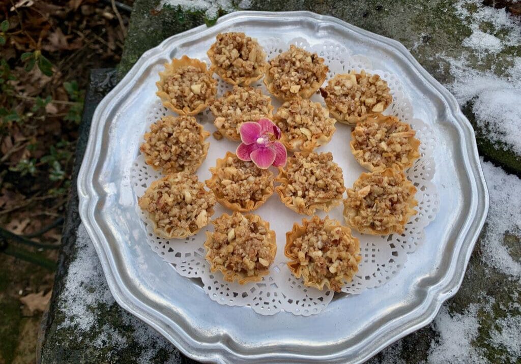 Nutty pastry tarts on a silver tray.