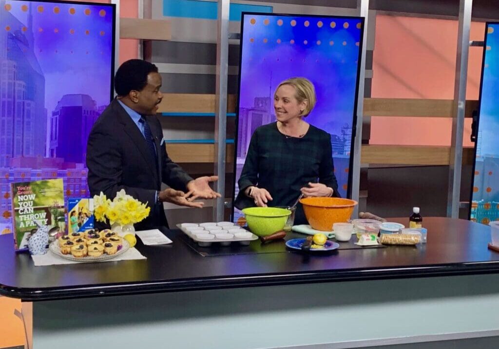 Two people preparing food on a cooking show.