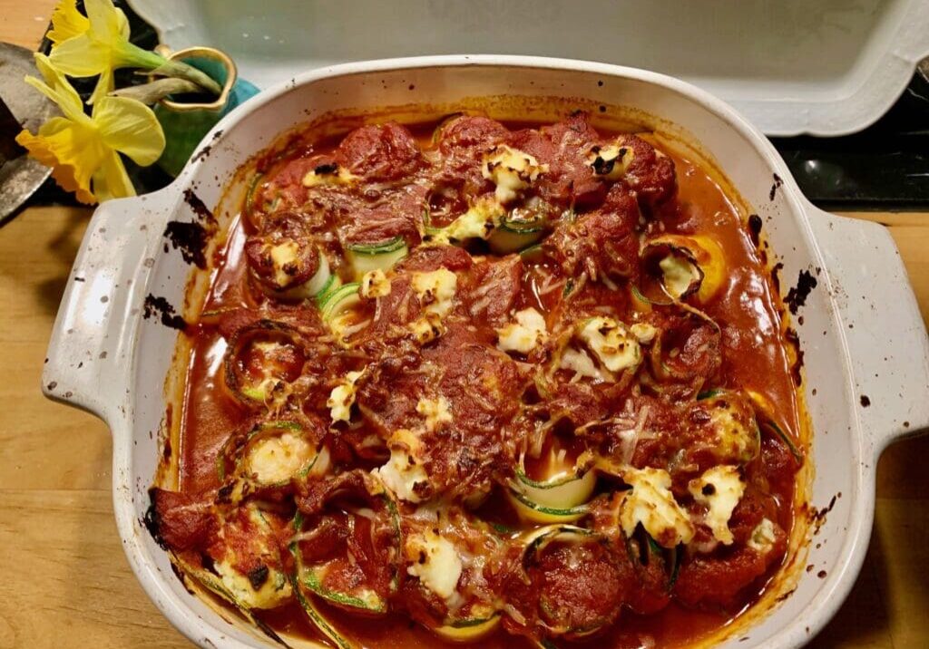 Baked zucchini rolls in tomato sauce.