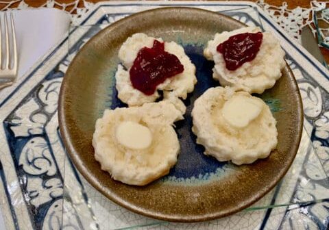 Biscuits with jam and butter on plate.