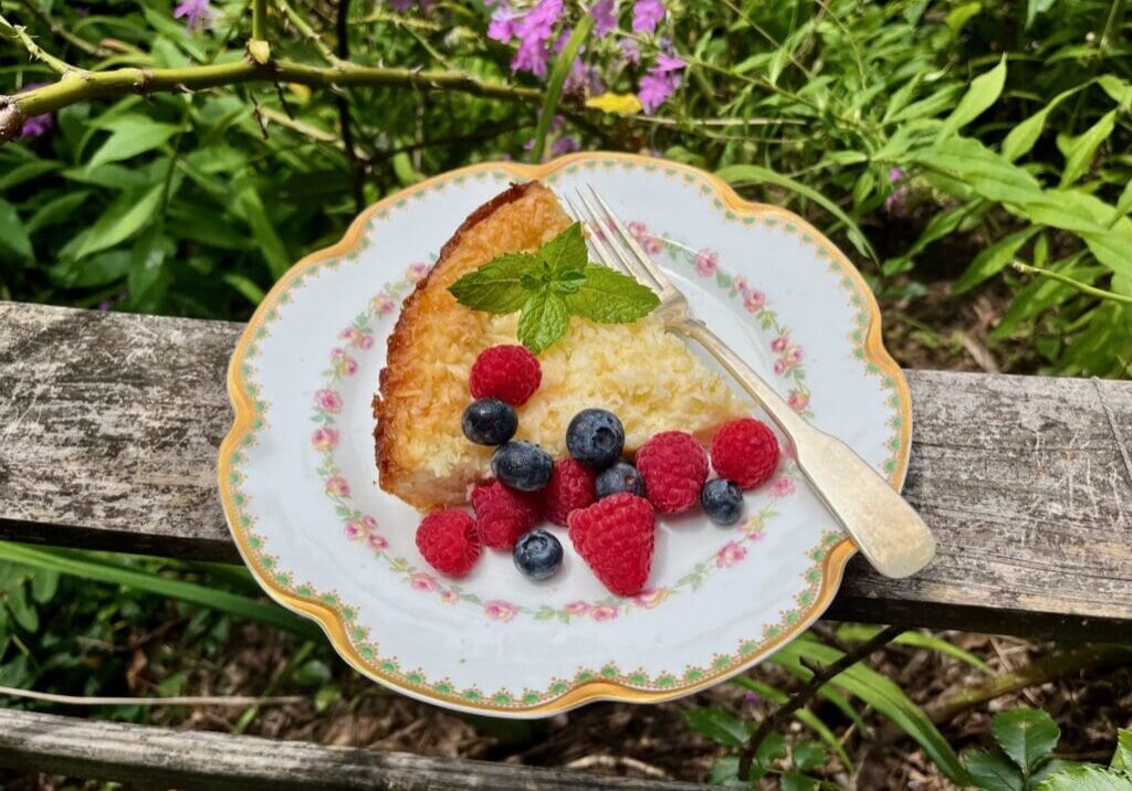 Coconut cake with berries on a plate.