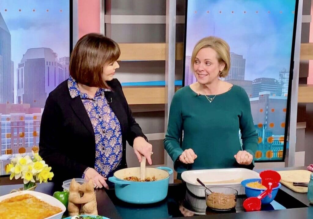 Two women cooking in a kitchen studio.