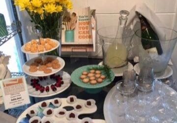 A table with snacks, drinks, and flowers.