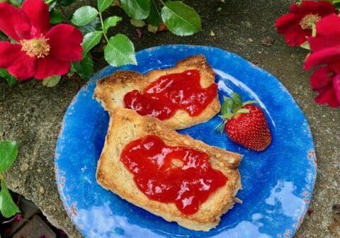 Two slices of toast with strawberry jam.