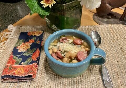 A bowl of white bean soup with sausage.