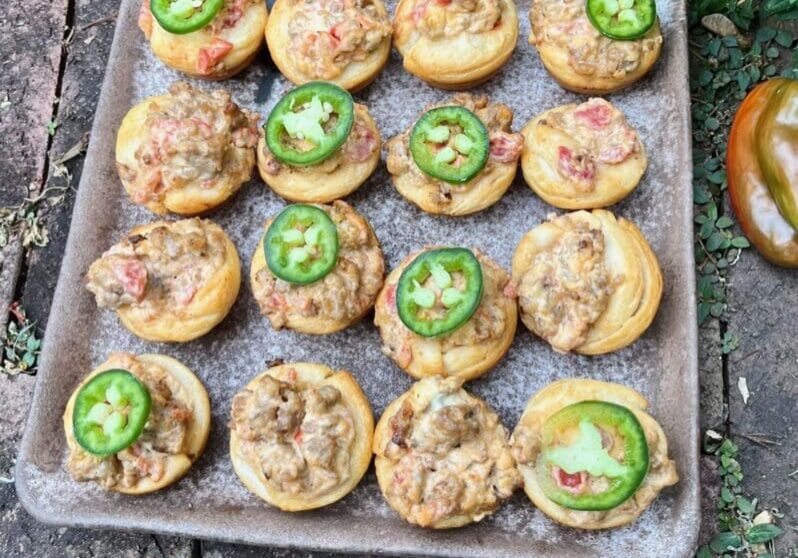 A tray of jalapenos and meat on top of some bread.