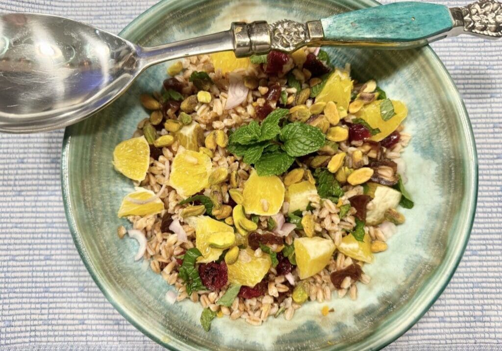 A bowl of food with rice and fruit on it.