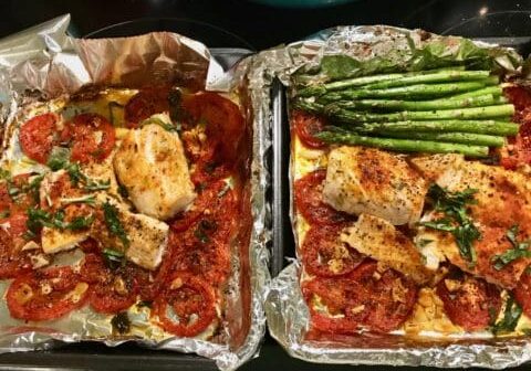 Baked fish with tomatoes and asparagus.